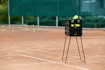 Box with tennis balls on court