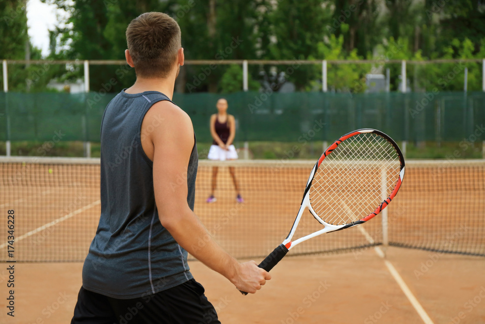 Sticker Young man and woman playing tennis on court