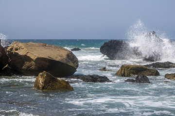 Beach with big stones in the surf and dark sky