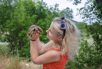 Girl hold the turtle on palm