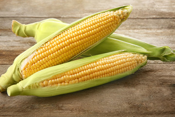 Fresh corn cobs on wooden table