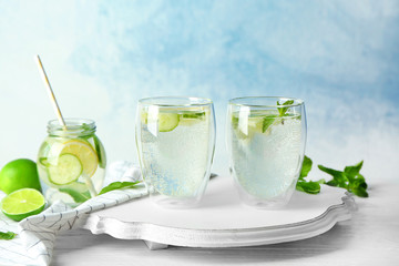 Delicious refreshing water with cucumber in glasses on wooden board