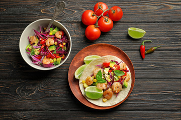 Plate with delicious shrimp taco on wooden table