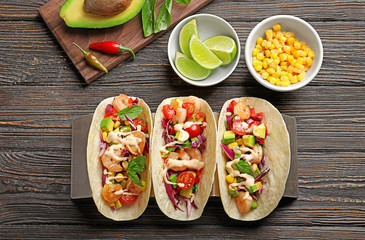 Holder with delicious shrimp tacos on wooden table