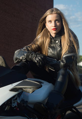 Obraz na płótnie Canvas Sexy biker girl in a leather jacket