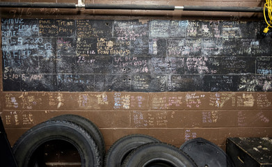 Tires lean on a wall where people recorded their personal bests in an old gym.