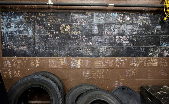 Tires lean on a wall where people recorded their personal bests in an old gym.