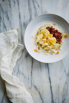 Breakfast bowl: Porridge bowl with dried fruits on marble background.