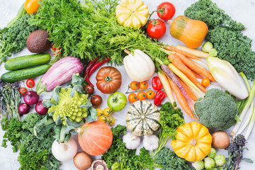 Organic farm crops, varieity of colorful organic vegetables and herbs on light grey stone background, top view, selective focus