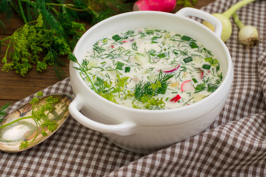 Okroshka. Summer light cold yogurt soup with cucumber, radish, eggs and dill on a wooden table. Wooden background. Close-up. Top view