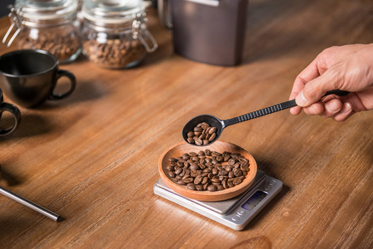 Man weighting coffee bean to prepare coffee