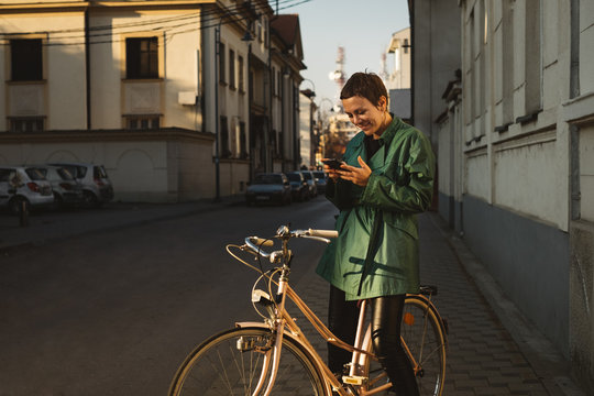 Pretty Woman Browsing on Her Phone While Sitting on a Bike