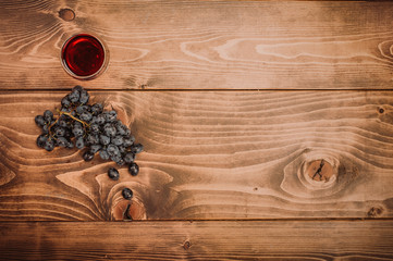 Glass of red wine and grapes on rustic wood table