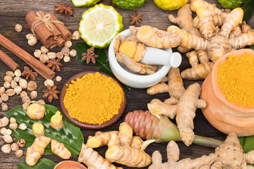 Turmeric powder,Turmeric in Mortar Grinder drugs and ingredient herbs on wooden background