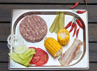 set of products for making burger - meat, bun, corn, bacon, tomato