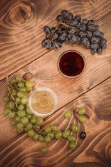 Red and white wine glasses and grape on wooden table