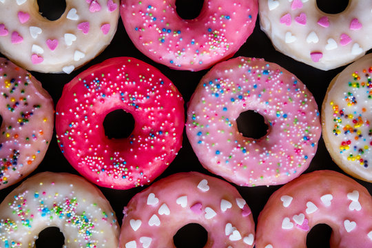 Pastel color donuts on dark background