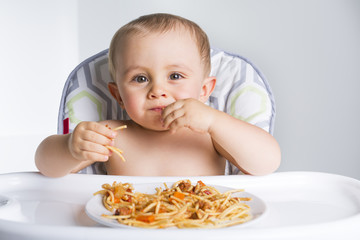 Little baby eating her dinner and making a mess