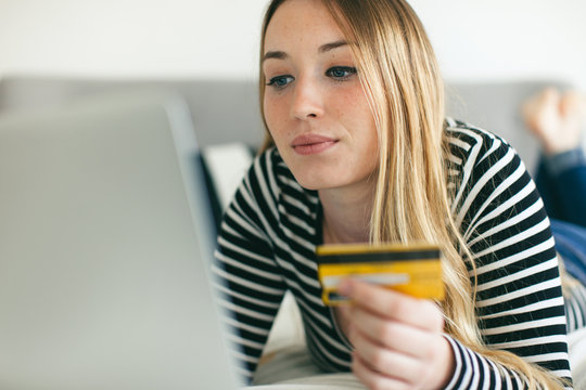 Woman shopping online with her credit card from home.