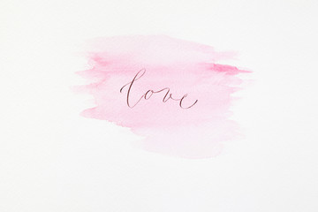 The word "love" in calligraphy on watercolor paint 