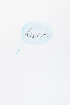 The word "dream" in calligraphy on a watercolor thinking bubble 