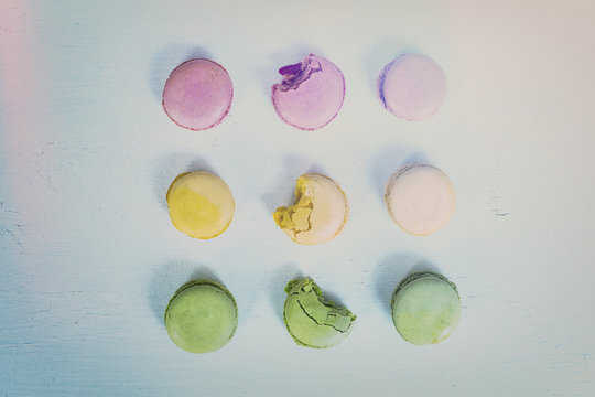 macarons with bites in various pastel colours with a light leak