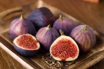 Beautiful ripe figs in rustic decorated wooden bowl