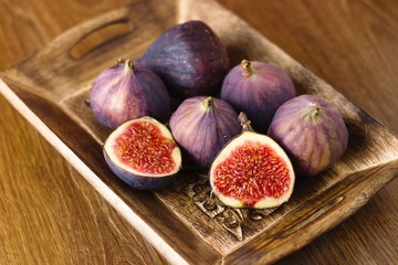 Beautiful ripe figs in rustic decorated wooden bowl
