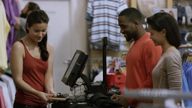  Couple in clothing store paying for a purchase with credit card