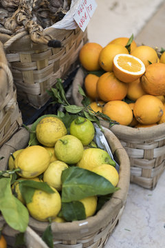 Baskets of oranges and lemons outside a store