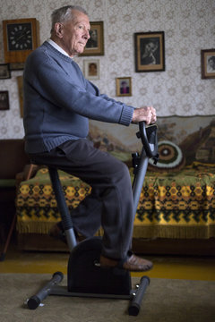 Old gentleman exercising insede his home
