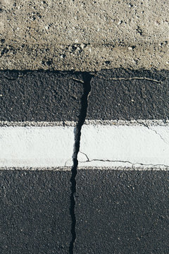 Crack in road and white boundary mark