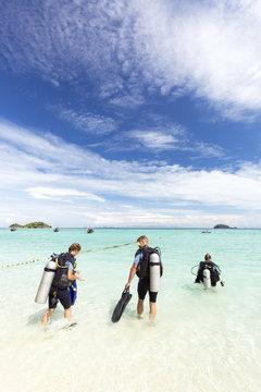 Beautiful young couple having Scuba Diving course with their instructor in tropics