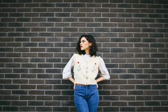 Caucasian brunette woman in fron of a brown wall - horizontal