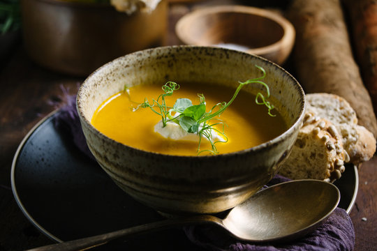 A bowl of soup with bread.