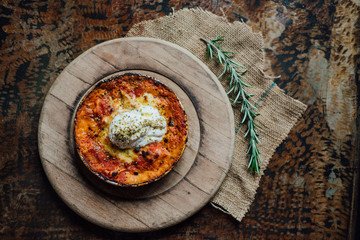 Lasagna meal in the rustic plate on wooden pad