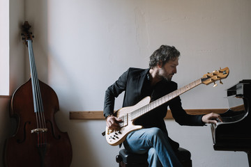 Male musician playing an electric bass guitar