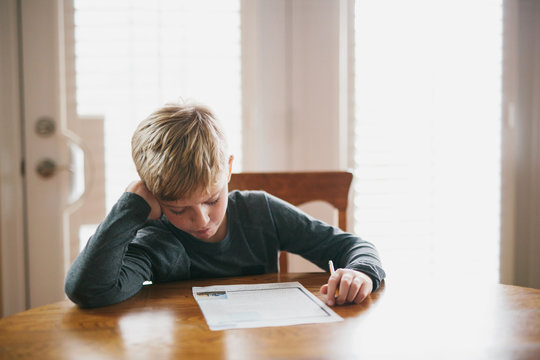 boy doing homework at the kitchen table