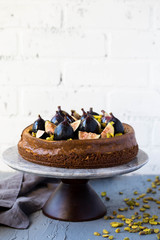 Fig Pistachio Cheesecake on a Marble Cake Stand Against Brick Wall Autumm Winter Holiday Season Dessert Copy Space