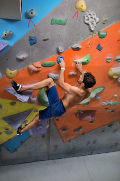 Young man rock climbing an artificial wall