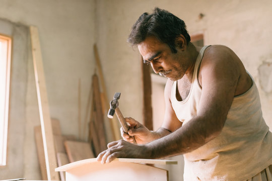 Carpenter with hammer hitting wood
