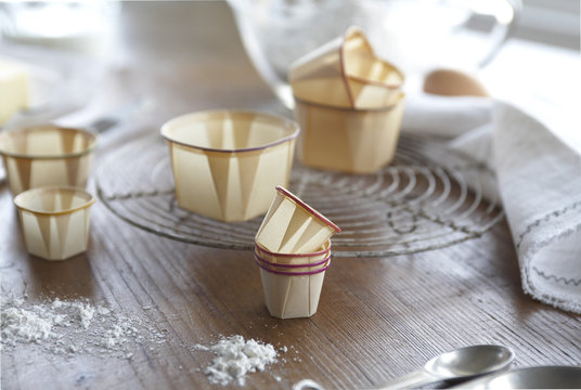 Waxed paper baking cups on wood surface with white linen napkins