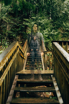 Long Exposure Of Man Standing On Steps Of Forest Trail Staircase