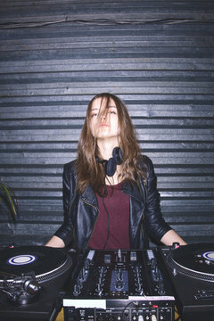 Portrait of attractive young female DJ at DJ desk
