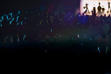 Colorfully backlit audience and a rock band on the stage
