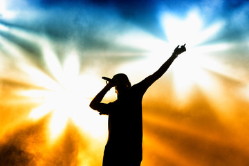 Silhouette of an unrecognizable man singing rap