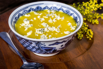Yellow soup with blue cheese topping