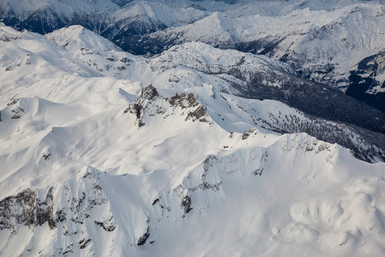 Scenic aerial landscape view of the beautiful snow covered mountains of British Columbia, Canada. Picture taken during winter near Squamish, BC.