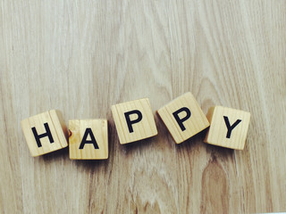 happy word wooden block on wooden background