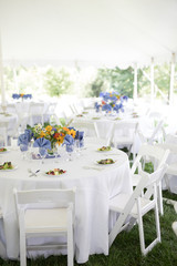 Wedding Reception with White Tablecloths and Colorful Centerpieces Outside Under a Large White Tent